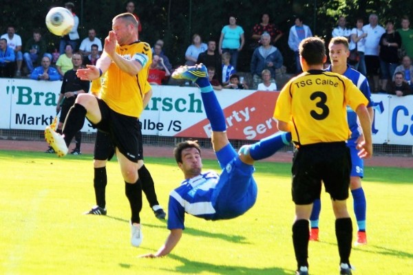 Der 2. Juli 2014 war einer der großen Tage der Abteilung Fußball der TSG Calbe. Zu einem Testspiel hatte sich der 1. FC Magdeburg, damals noch in der Regionalliga aktiv, angekündigt. Mit dabei waren auch die Stars der Landeshauptstädter. Und die TSG Calbe als Gastgeber verkaufte sich gegen die Profis achtbar. Mit einem Sieg hatte keiner gerechnet, doch auch mit einer 0:4-Niederlage nur die Wenigsten. Einer setzte der ganzen Partie aber die Krone auf: FCM-Stürmer Christian Beck (Foto, Mitte). Beim Stand von 2:0 für die Magdeburger segelte ein hoher Ball in den Strafraum der Calbenser und Beck setzte artistisch zum Fallrückzieher an. Unter dem Raunen der Zuschauer flog der Ball wie an der Schnur gezogen und schlug im Kasten der Calbenser zum vorentscheidenden 3:0 ein. | Foto: Falko Haltenhof