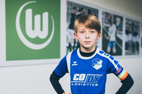 Der calbenser F-Jugendkapitän Jakob Sieche im TSG-Trikot mit Regenbogenbinde in den Räumlichkeiten des VfL Wolfsburg. | Foto: Verein